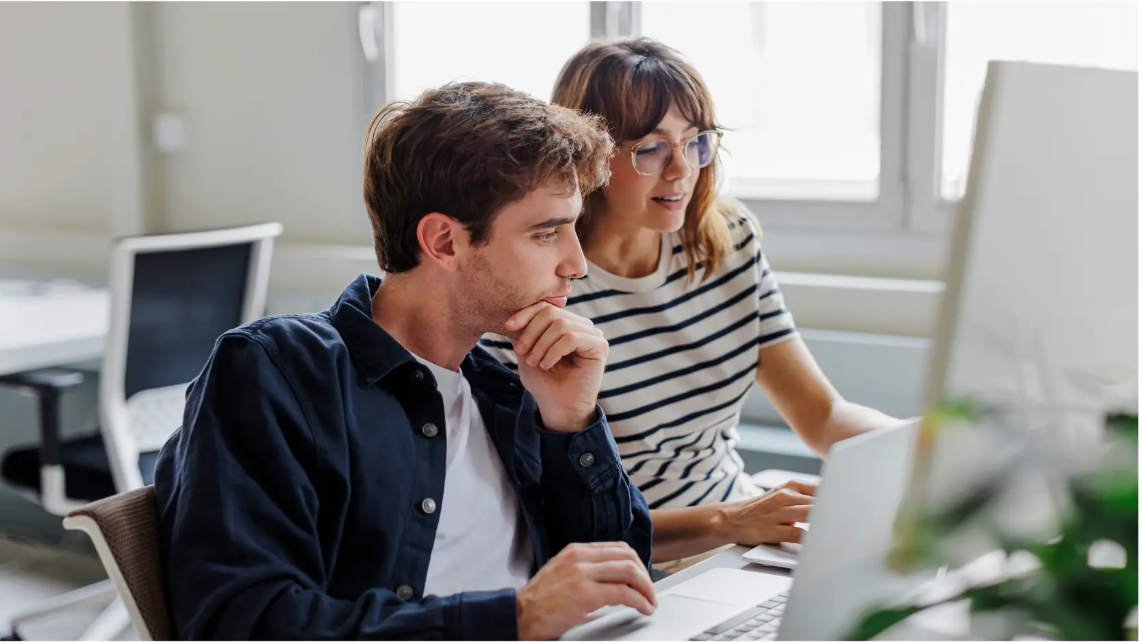 Payroll professionals working on computer in an office
