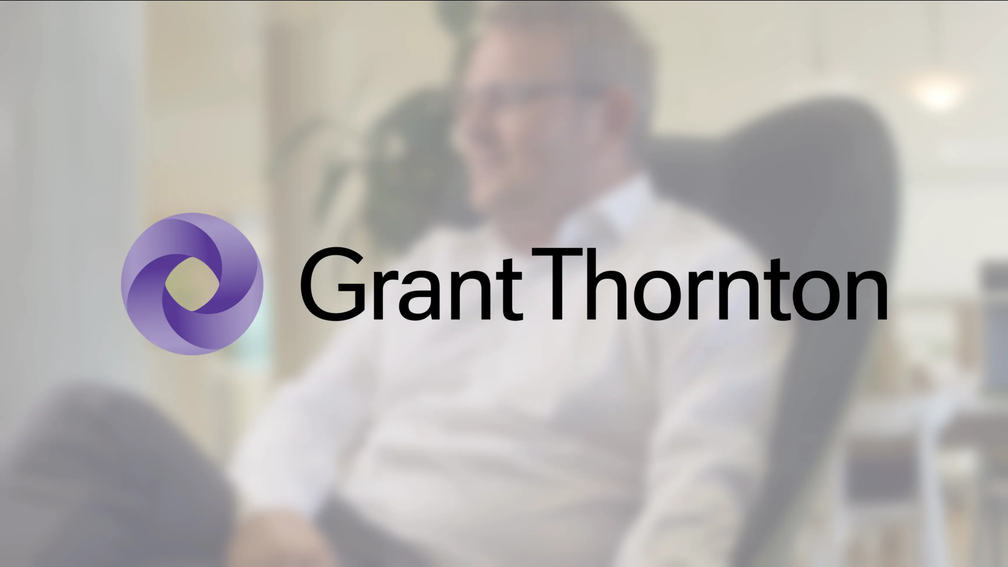 Man sitting in chair with Grant Thornton logo on top