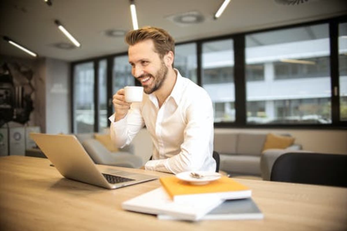 MAN OP STOEL MET BEKER KOFFIE